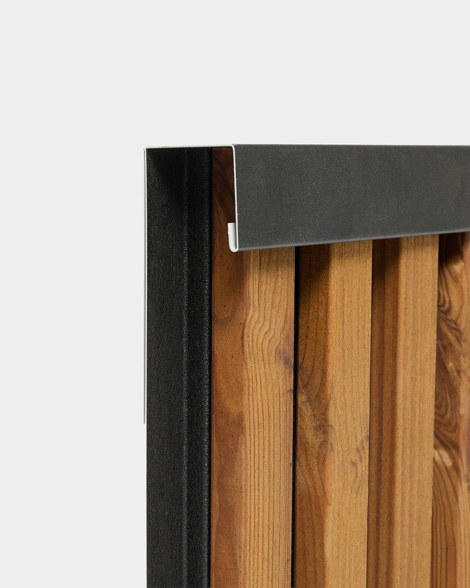 Närbild av WoodUpp Aluwood 240 cm avslutningsprofil med en black aluminiumkant för utomhuspaneler för fasad, visad mot en vit bakgrund.